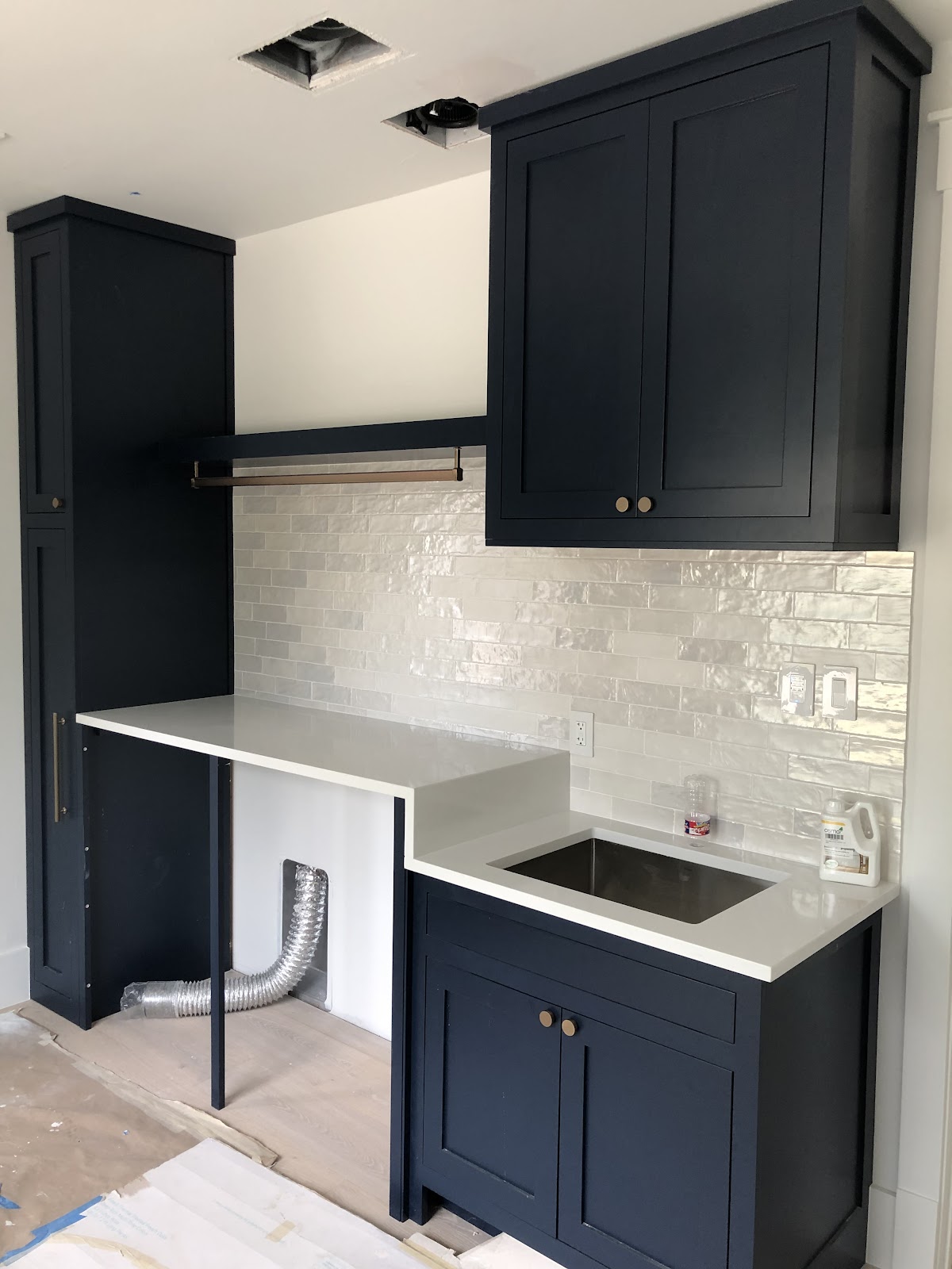 Kitchen remodel in progress with navy cabinets and quartz countertop